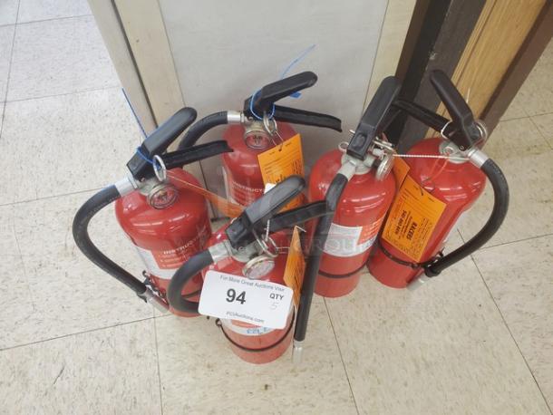 Lot of 5 red fire extinguishers with attached hoses and labels. Includes auction tag marked "94, QTY 5".