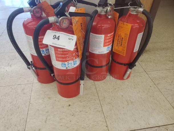 Lot of 5 red fire extinguishers with hoses and labels, in good condition, auction tag indicates quantity and lot number.