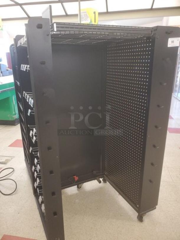 Black metal checklane shelving unit on wheels, pegboard sides, adjustable shelves; ideal for retail display; good condition.