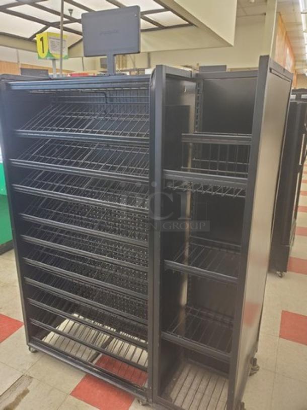 Black checklane shelving unit with multiple wire shelves, rolling casters, and upper signage bracket. Ideal for retail use.