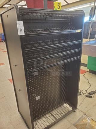 Checklane shelving unit, black metal, four-tier wire shelves, pegboard back, casters for mobility, auction tag visible.