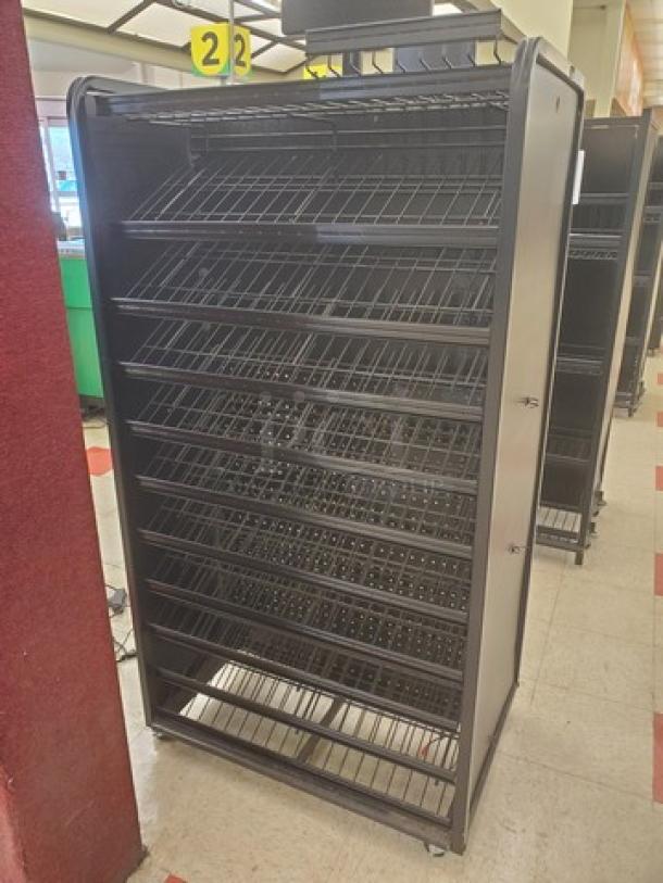 Black checklane shelving unit with multiple angled wire shelves, used condition, suitable for retail displays.