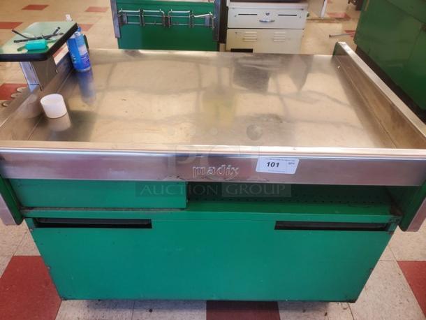 Stainless steel supermarket checkout counter, green base, branded "Madix," with number tag "101." Used condition.
