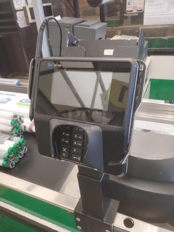 Supermarket checkout counter with integrated card reader, touchscreen display, and conveyor belt. Clean and functional condition.