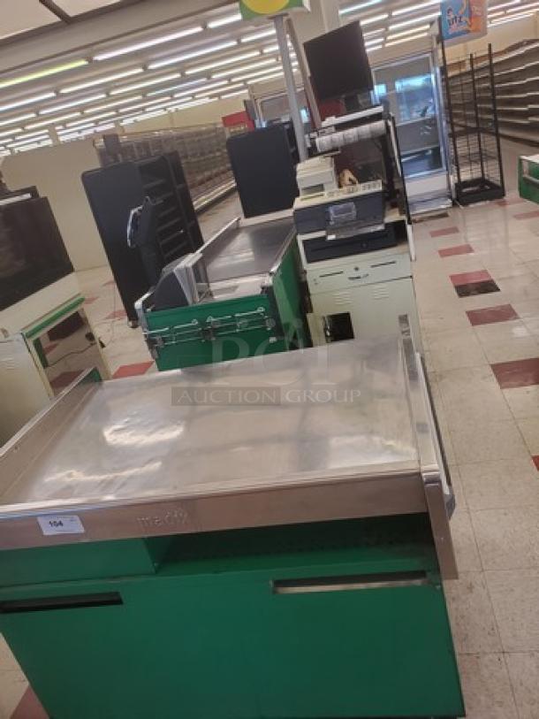 Green supermarket checkout counter with a stainless steel surface and integrated cash register. Good condition.