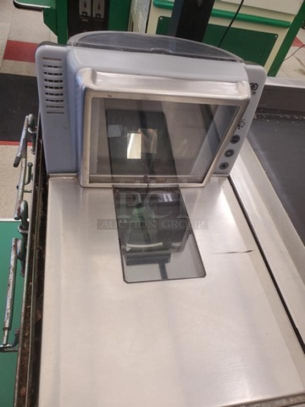 Supermarket checkout counter with built-in scanner and keypad, metallic finish, used condition.