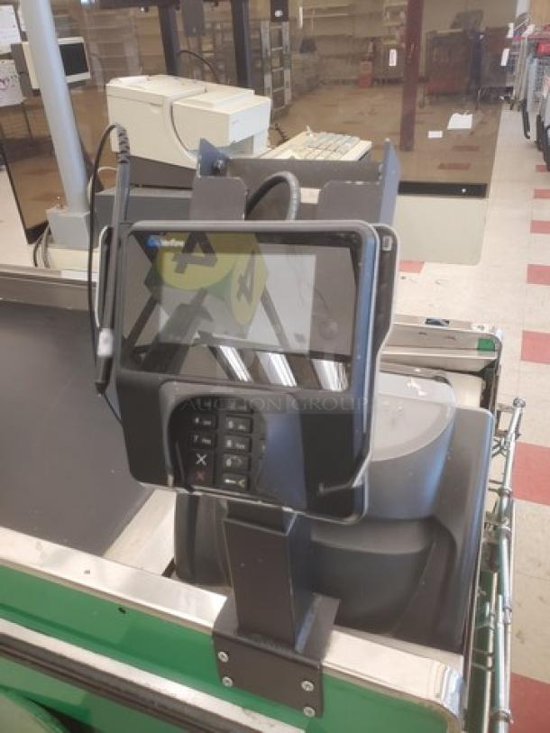 Supermarket checkout counter with POS system, card reader, and conveyor belt; in used condition, black and green finish.