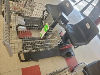 Motorized shopping cart with seat and basket, in good condition. Includes visible control panel and safety instructions.