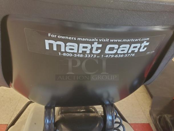 Motorized shopping cart with Mart Cart logo and contact info; black seat; condition appears used.
