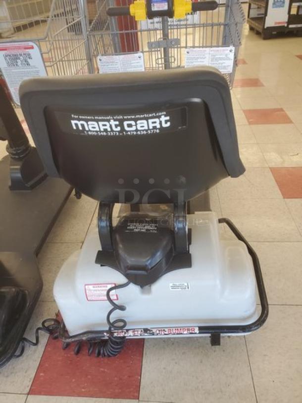 Motorized shopping cart featuring Mart Cart branding, black seat, white base, and steering handlebars. Good condition.