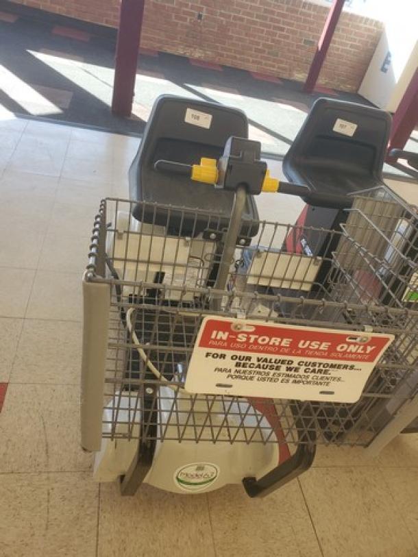 Motorized shopping cart with dual seats, control panel, and a "Sparky" logo. In-store use only sign visible.