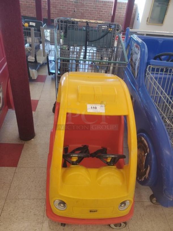 Yellow and red cartoon car shopping cart with metal basket, child seatbelts, and front wheels. Item number 110.