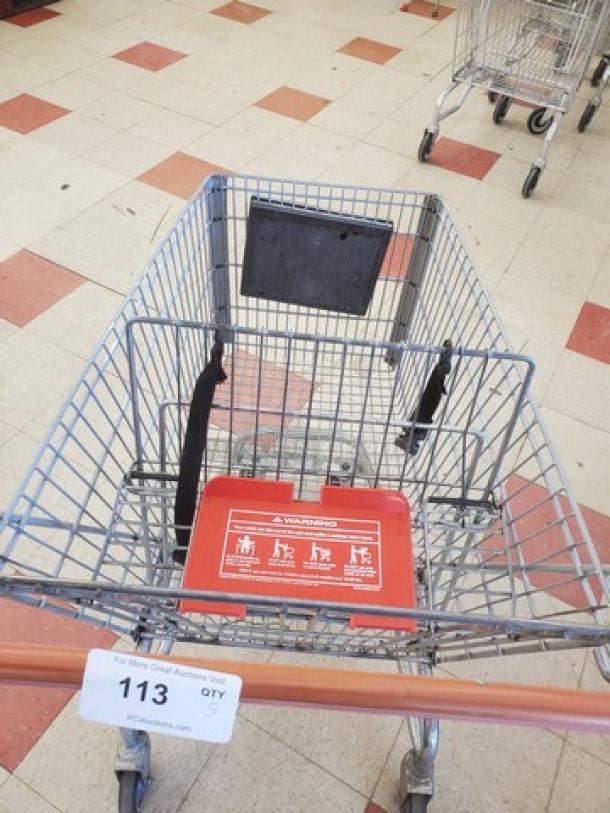 Lot of 5 metal shopping carts in good condition, featuring child seats and warning labels. Auction tag showing quantity.