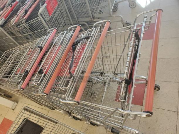 Lot of 5 metal shopping carts with red handles. Good condition, standard size, stackable design for efficient storage.