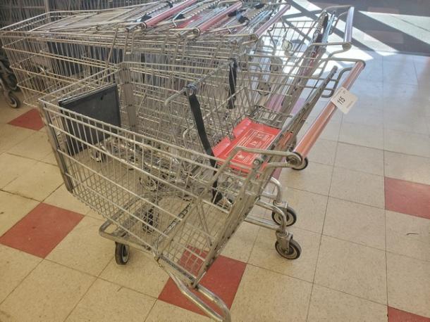 Lot of 5 metal shopping carts with red handles. Used condition, includes labels "5XBID". Wheels appear functional.