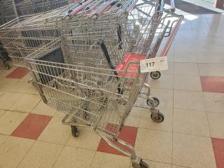 Set of 5 metal shopping carts in good condition, with swivel wheels and red handles. Tag marked "117" and quantity "5".