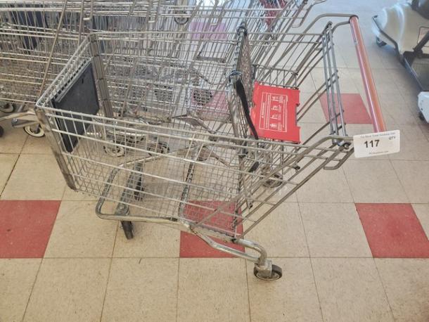 Lot of 5 metal shopping carts, used condition, red handle markings visible.
