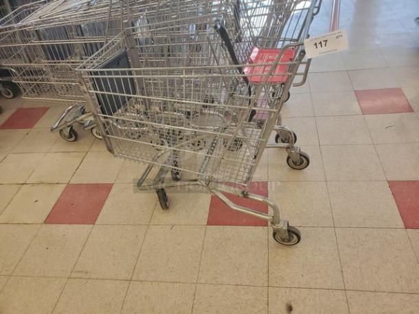 Lot of 5 metal shopping carts in used condition, featuring swivel wheels and child seats. Tag reads "117 QTY 5XBID."