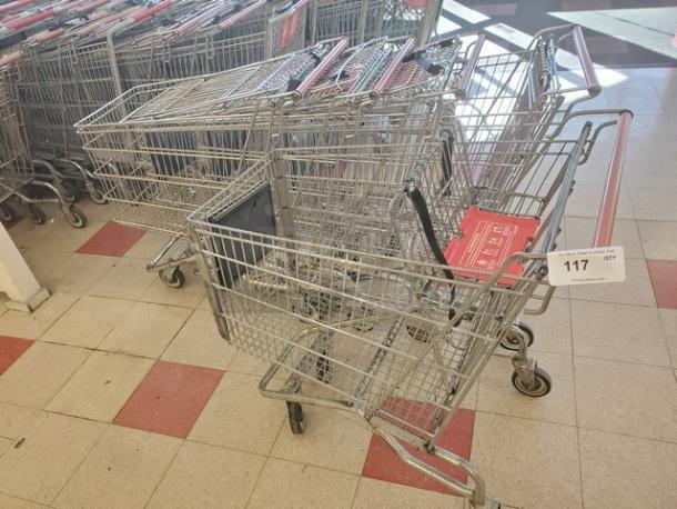 Lot of 5 metal shopping carts in good condition, red and silver finish, with swivel casters; auction tag reads "117".
