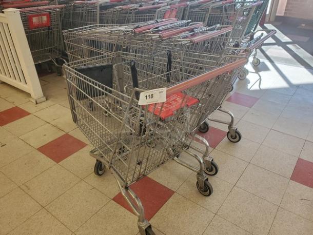 Lot of 5 metal shopping carts with red handles, in good used condition, featuring a visible tag labeled "118."