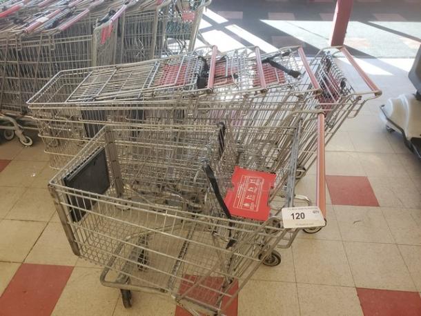 Lot of 5 metal shopping carts with red handles and child seats, in used condition. Quantity tag shows "120 QTY."