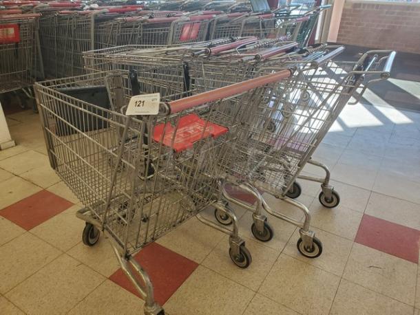 Lot of 5 metal shopping carts with red handles and seats, in good condition. Tag marked "121."