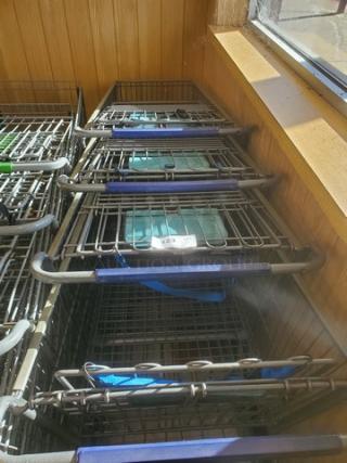 Lot of 4 shopping carts stacked, metal frame, blue accents, in good condition; tag labeled "23".