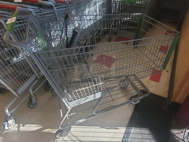 Lot of 4 metal shopping carts in good condition, with swivel wheels and sturdy handles, ideal for retail use.
