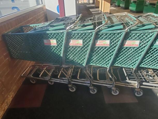 Lot of 3 green shopping carts with metal frames, in used condition. Labels read "Shoppers Compliments." Suitable for retail use.
