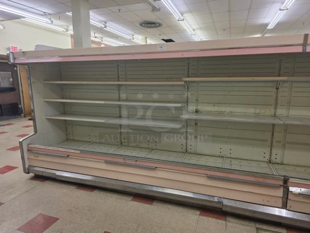 12' Hussmann DM12ZA multi-deck case, 1992 model, used condition, with empty shelving in a store setting. Buyer removal required.