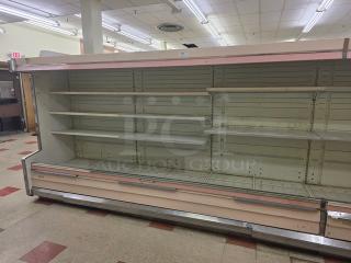 12' Hussmann DM12ZA multi-deck case, 1992 model, used condition, with empty shelving in a store setting. Buyer removal required.