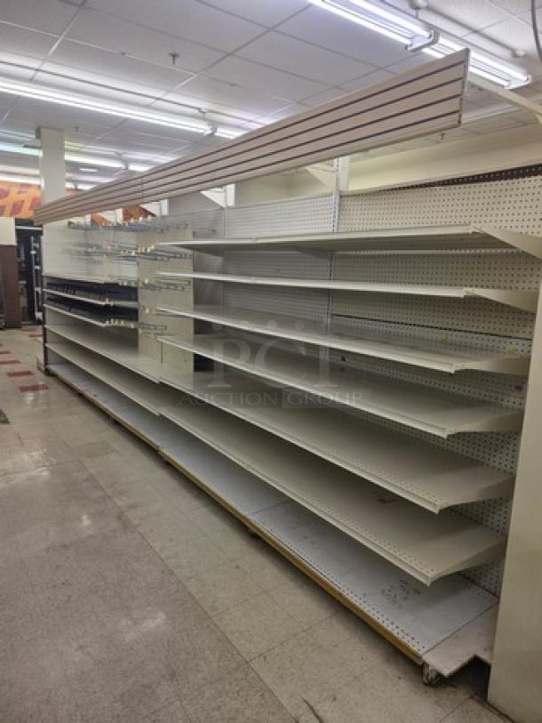 Double-sided gondola shelving, 23 feet long, metal construction, used condition, adjustable shelves, buyer must remove.