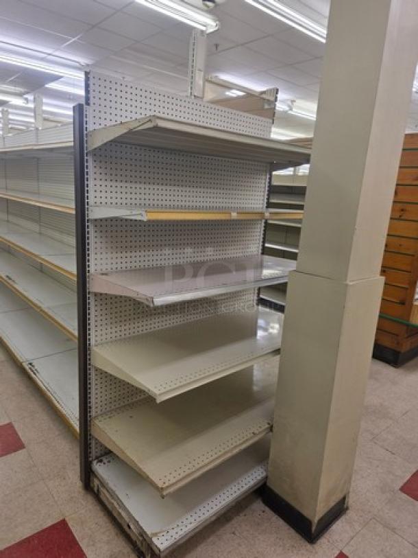 Double-sided gondola shelving, 23' long. Features metal pegboard backing, adjustable shelves. Buyer must remove. Good condition.
