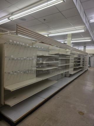 Single sided gondola shelving, 40 feet long, featuring multiple adjustable shelves. Used condition with metal perforations.