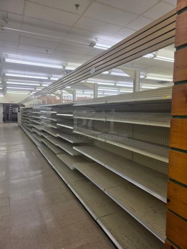 Double-sided gondola shelving, 63-foot, with multiple adjustable shelves in good condition. Buyer must remove.