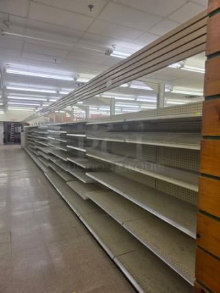 Double-sided gondola shelving, 63-foot, with multiple adjustable shelves in good condition. Buyer must remove.