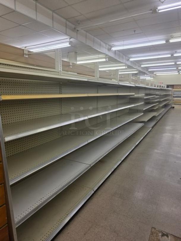 Double-sided gondola shelving, 63', steel, good condition, multiple levels. Buyer must remove. Ideal for retail display.