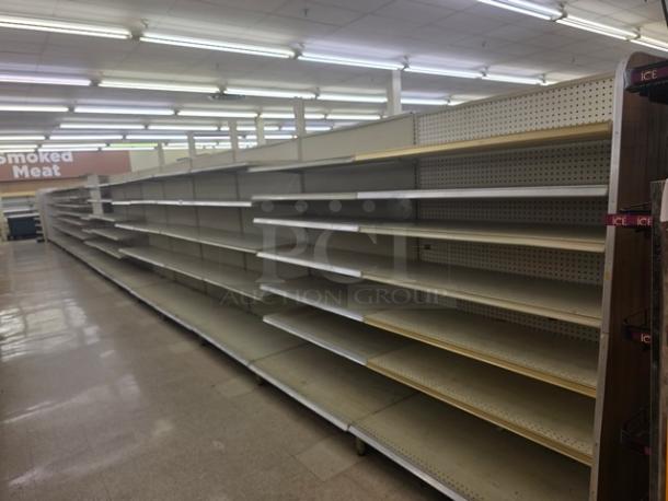Double-sided gondola shelving, 63' length, metal and wood, beige color, used condition, buyer to remove.