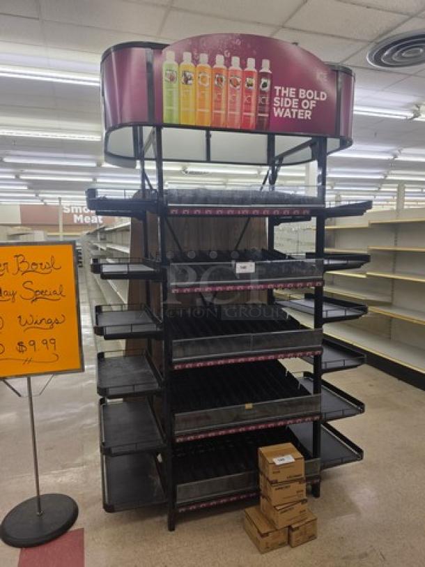 Gondola shelving with black metal frame and multiple adjustable shelves. Includes top promotional sign. Buyer must remove.