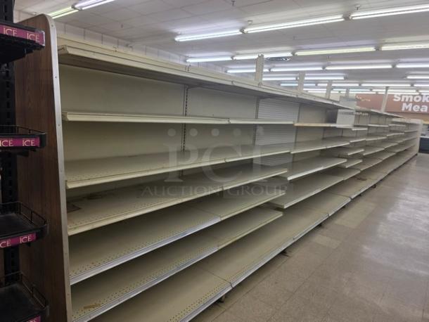 Double-sided gondola shelving, 63 feet, beige, metal, moderate wear, buyer must remove. 