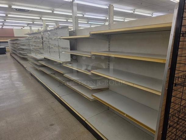 Double-sided gondola shelving, 63', white with beige trim, multiple adjustable shelves, fair condition. Buyer must remove.