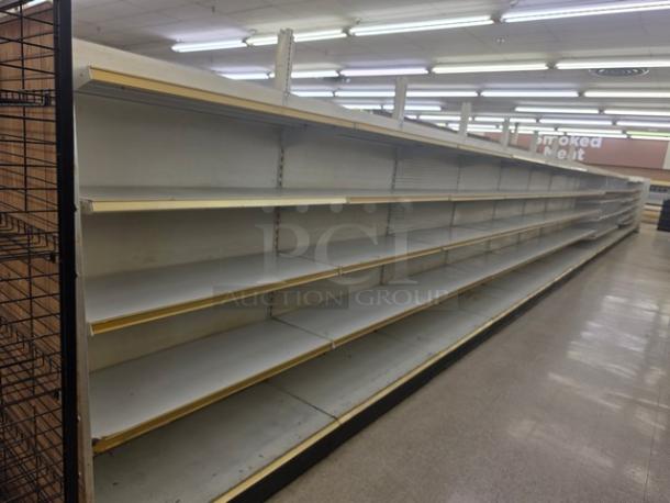 Double sided gondola shelving, 63 feet long, used condition, features adjustable shelves, durable metal construction. Buyer must remove.