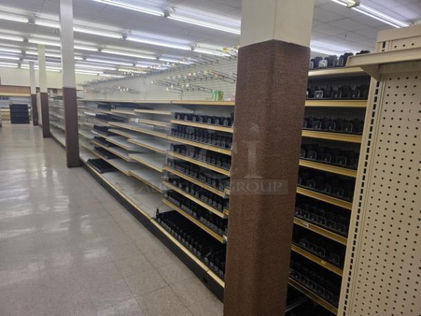 Double-sided gondola shelving, 65 feet, white with adjustable shelves. Buyer must remove. Suitable for retail displays.