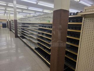 Double-sided gondola shelving, 65 feet, white with adjustable shelves. Buyer must remove. Suitable for retail displays.