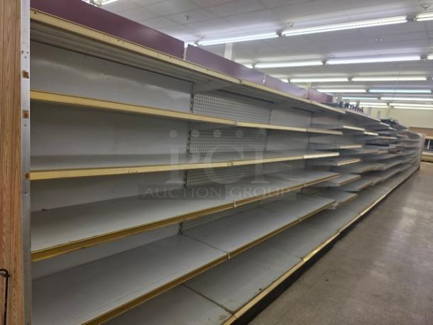 Double-sided gondola shelving, 63 feet, metal shelves with wooden trim, used condition, buyer removal required.