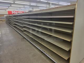 Single-sided gondola shelving, 63-feet long, features multiple adjustable metal shelves, fair condition. Buyer must remove.