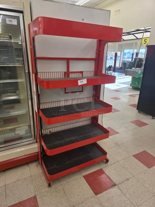 Red retail display shelf with five wire mesh tiers, standing on wheels. Good condition. Price tag visible.