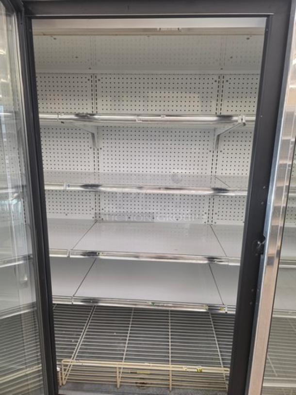 Kysor/Warren freezer display case model LV5H1-5U, no compressor, metal shelves, sold by door, visible perforated back panel.