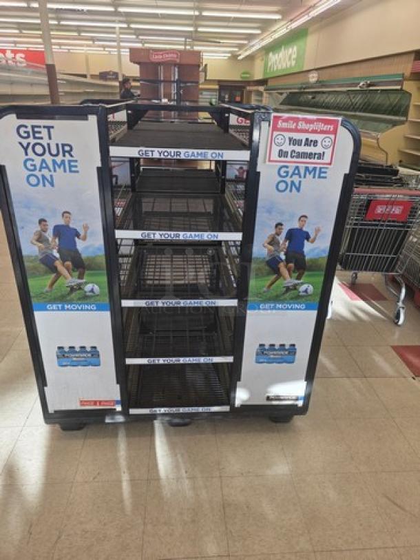Retail display rack with metal shelves, promotional "Get Your Game On" signage, and camera warning label. Good condition.