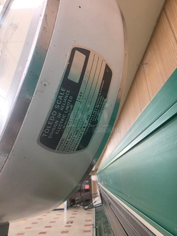 Toledo Model 2110 Commercial Hanging Scale, metal body, clear faceplate, visible label with model details, good condition.